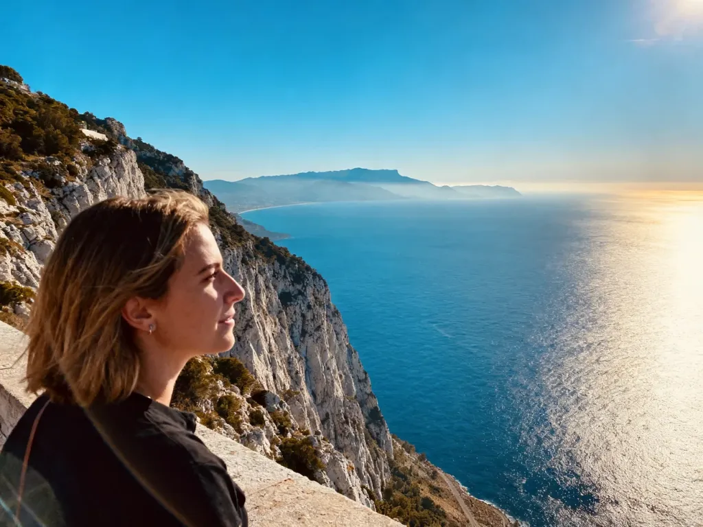 Kobieta podziwiająca panoramę Morza Śródziemnego i wybrzeża Afryki ze szczytu Skały Gibraltarskiej w świetle zachodzącego słońca.
